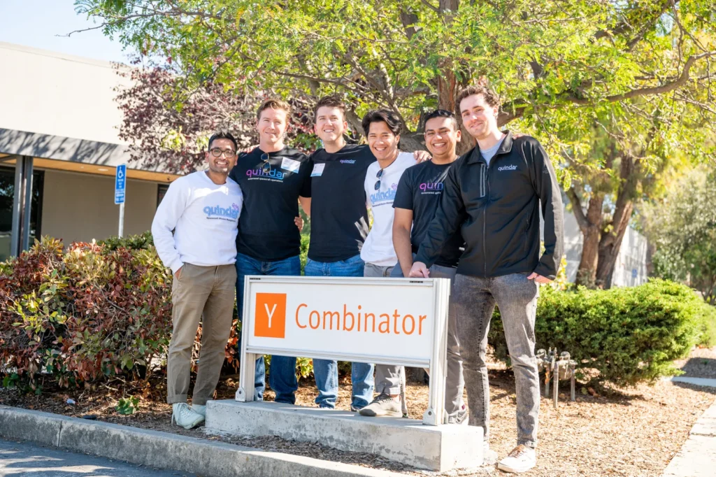 Image of Quindar's Founding Team Behind Y-Combinator Sign